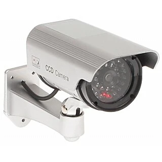 Atrapa kamery CCD w srebrnej obudowie z widocznymi diodami LED, zamontowana na regulowanym uchwycie ściennym. Produkt imituje prawdziwą kamerę monitoringu, co zwiększa bezpieczeństwo poprzez odstraszanie potencjalnych intruzów.