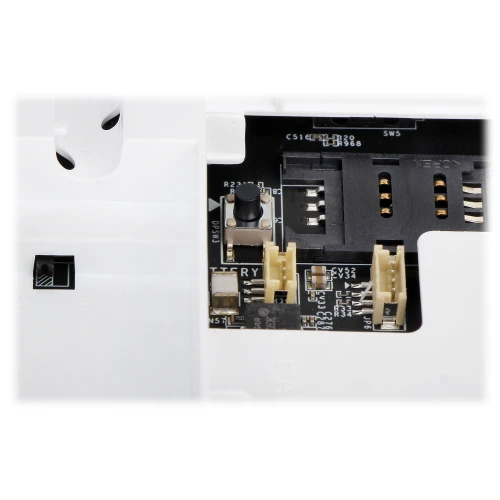 Zbliżenie na wnętrze urządzenia elektronicznego, ukazujące złącza i komponenty na płytce drukowanej. Widoczne są gniazda, przyciski oraz elementy montażowe.