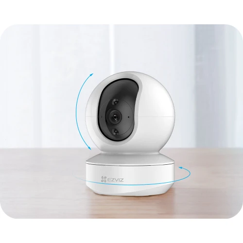 Biała kamera IP EZVIZ TY1 o kulistym kształcie, umieszczona na obrotowej podstawie, umożliwiającej pełny zakres ruchu. Urządzenie posiada widoczne logo EZVIZ i jest ustawione na jasnym, drewnianym blacie.