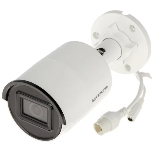 Biała kamera IP Hikvision z cylindrycznym korpusem i czarnym obramowaniem obiektywu, zamontowana na uchwycie ściennym. Widoczne są również przewody połączeniowe wychodzące z tylnej części kamery.