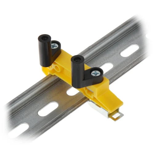 Zdjęcie przedstawia żółty uchwyt montażowy LPCB-1 zamocowany na metalowej szynie perforowanej. Uchwyt posiada dwa czarne elementy z otworami na śruby, które umożliwiają stabilne przymocowanie do szyny.