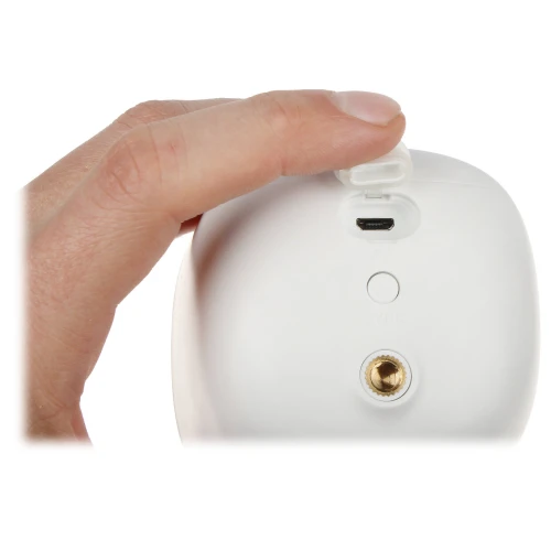 Na zdjęciu widać białe urządzenie z portem mini USB, trzymane przez dłoń. Obok portu znajduje się przycisk oraz otwór montażowy.