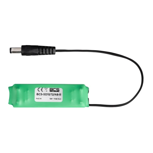 Na zdjęciu znajduje się zielona przetwornica obniżająco-stabilizująca z czarnym kablem zakończonym wtykiem. Na obudowie widoczne są oznaczenia techniczne i logo producenta.