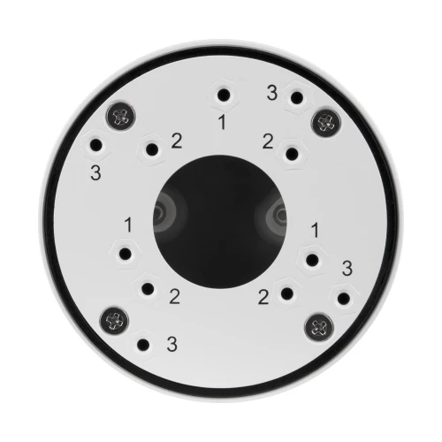 Okrągła, biała puszka montażowa do kamer z kilkoma otworami i numerowanymi oznaczeniami na powierzchni. W centrum znajduje się ciemny, okrągły obszar, otoczony przez cztery śruby.