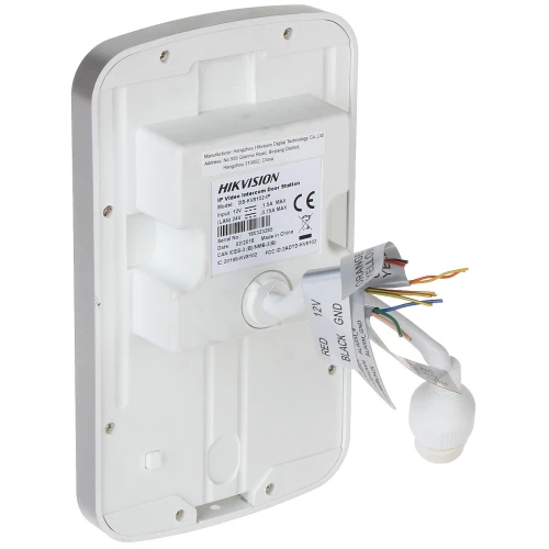 Na zdjęciu znajduje się tylna część stacji bramowej IP Hikvision, z widocznymi etykietami technicznymi i wystającymi przewodami. Obudowa jest prostokątna, w kolorze białym, z zaokrąglonymi krawędziami.