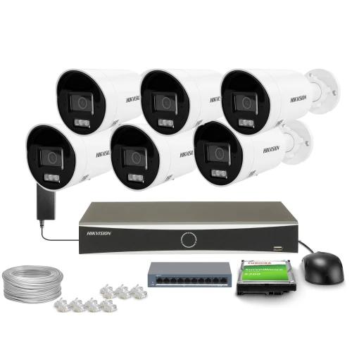 Na zdjęciu znajduje się zestaw do monitoringu, który obejmuje sześć kamer, rejestrator, dysk twardy, przełącznik sieciowy, kabel oraz złącza. Wszystkie elementy są ułożone na białym tle, prezentując kompletny system nadzoru.