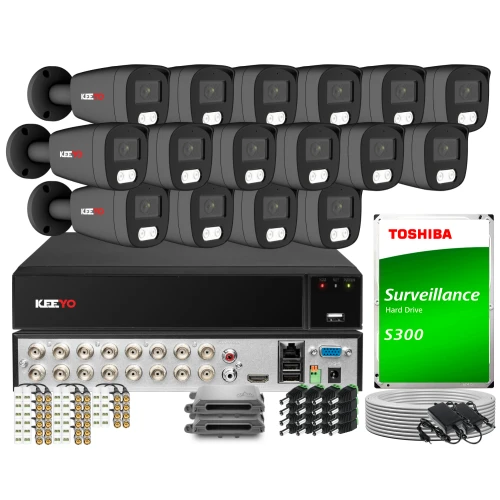 Na zdjęciu znajduje się zestaw do monitoringu marki Keeyo, składający się z szesnastu kamer, rejestratora oraz dysku twardego Toshiba S300. W tle widoczne są również akcesoria montażowe i kable połączeniowe.
